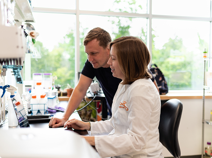 Scientists reviewing antibody discovery data on a lab computer.