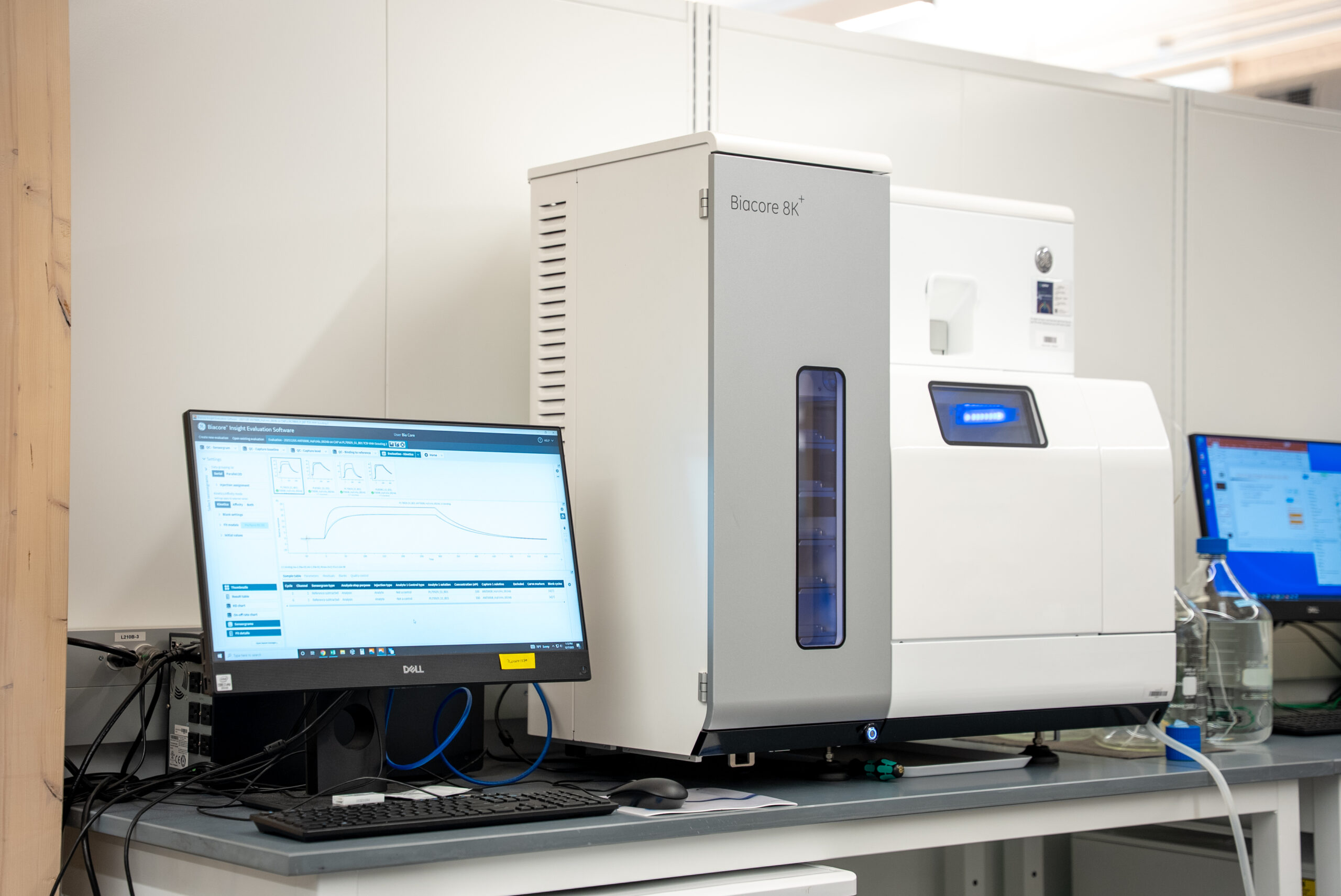 Biacore instrument on a lab workbench used for measuring protein binding affinity.